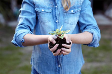 people in autumn - Close up of girl holding plant in pot soil Stock Photo - Premium Royalty-Free, Code: 649-07239024