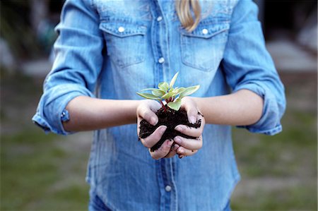 people in a garden - Close up of girl holding plant in pot soil Stock Photo - Premium Royalty-Free, Code: 649-07239024