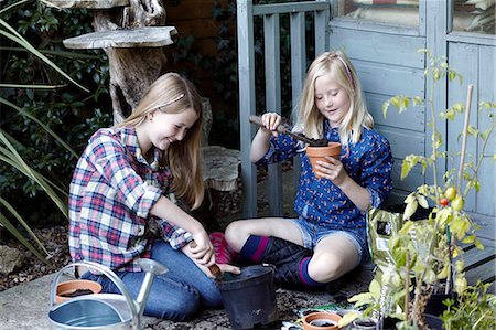 Two girls in garden planting seeds into pots Stock Photo - Premium Royalty-Free, Code: 649-07239021