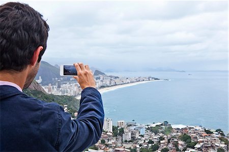 Young man photographing with mobile phone, Casa Alto Vidigal, Rio De Janeiro, Brazil Foto de stock - Sin royalties Premium, Código: 649-07239099