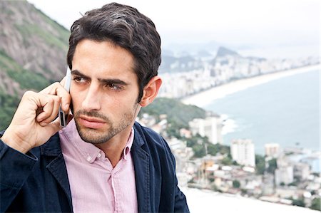 portrait looking away not happy - Young man on mobile, Casa Alto Vidigal, Rio De Janeiro, Brazil Stock Photo - Premium Royalty-Free, Code: 649-07239093