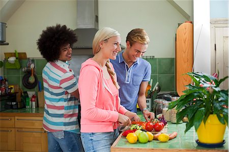 simsearch:649-07239130,k - Group of friends preparing vegetables in kitchen Foto de stock - Sin royalties Premium, Código: 649-07239129