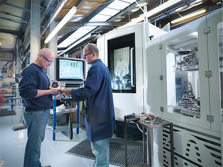 quality - Engineers inspecting part at computer numerical controlled lathe (CNC) in factory Stock Photo - Premium Royalty-Free, Code: 649-07239238