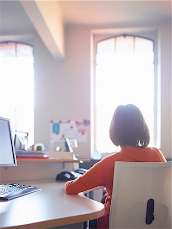 someone sitting at a desk backside - Female office worker sitting at desk, rear view Stock Photo - Premium Royalty-Free, Code: 649-07239303