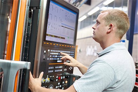 simsearch:649-07239349,k - Worker looking at computer monitor in engineering factory Stock Photo - Premium Royalty-Free, Code: 649-07239361