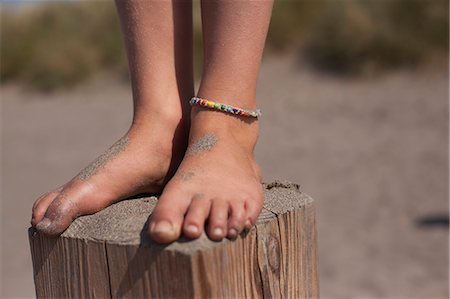 elementary age feet - Girl standing on wooden groyne, Wales, UK Stock Photo - Premium Royalty-Free, Code: 649-07239460