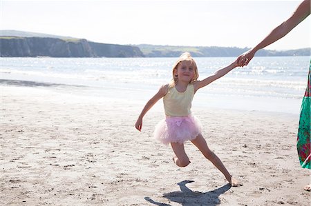 people holding hands on beach - Mother and daughter wearing tutu running on beach, Wales, UK Stock Photo - Premium Royalty-Free, Code: 649-07239471