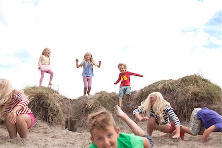 sieben (zahl) - Group of children jumping off sand dunes, Wales, UK Stockbilder - Premium RF Lizenzfrei, Bildnummer: 649-07239491