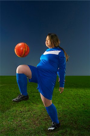 Female footballer playing keepy uppy with ball Stock Photo - Premium Royalty-Free, Code: 649-07239522