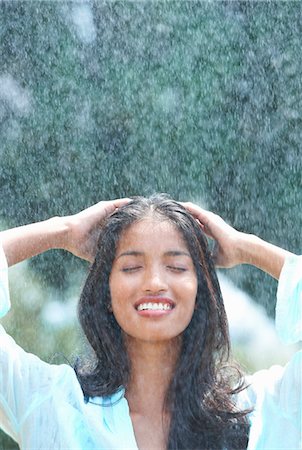 satisfied sexually - Young woman washing hair in rain Stock Photo - Premium Royalty-Free, Code: 649-07239548