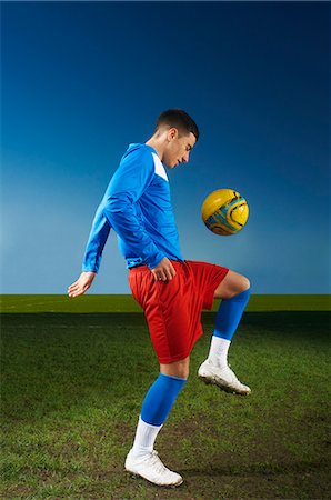 simsearch:614-06897429,k - Young man playing keepy uppy with football Photographie de stock - Premium Libres de Droits, Code: 649-07239540