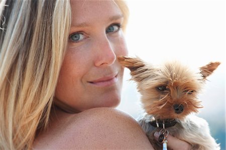 Mature woman holding pet dog, looking over shoulder Photographie de stock - Premium Libres de Droits, Code: 649-07239576