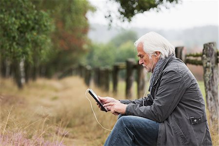 side view of senior with computer - Senior man using digital tablet Stock Photo - Premium Royalty-Free, Code: 649-07239715