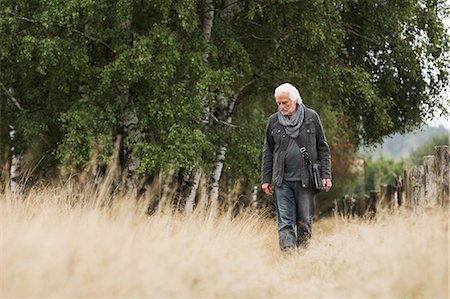 Senior man walking in meadow Stock Photo - Premium Royalty-Free, Code: 649-07239710