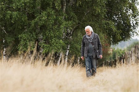 seniors walking alone - Senior man walking in meadow Stock Photo - Premium Royalty-Free, Code: 649-07239710