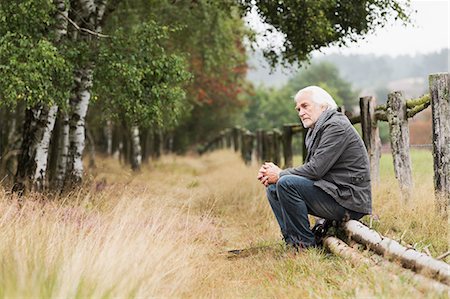 senior man introspective - Senior man sitting on log Stock Photo - Premium Royalty-Free, Code: 649-07239713