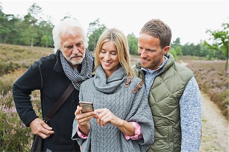 daughter and senior father - Mid adult woman using camera phone Stock Photo - Premium Royalty-Free, Code: 649-07239725