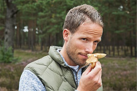 Mid adult man smelling mushroom Fotografie stock - Premium Royalty-Free, Codice: 649-07239738