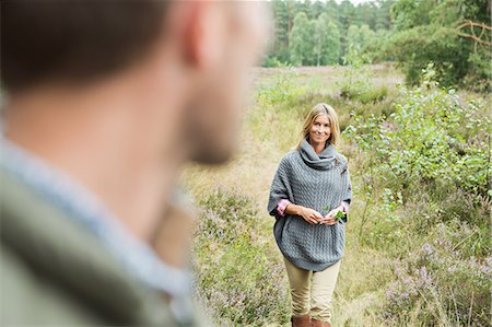 simsearch:649-07239777,k - Mid adult woman holding leaf, man blurred in foreground Photographie de stock - Premium Libres de Droits, Code: 649-07239748