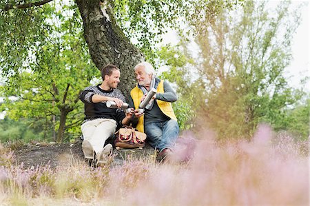 senior citizen and son two people - Father and adult son drinking coffee from flask Stock Photo - Premium Royalty-Free, Code: 649-07239756