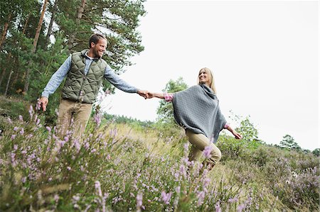 simsearch:649-07239777,k - Mid adult couple holding hands in meadow Fotografie stock - Premium Royalty-Free, Codice: 649-07239752