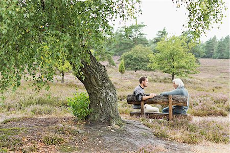 senior citizen and son two people - Senior man and mid adult man sitting on bench Stock Photo - Premium Royalty-Free, Code: 649-07239761