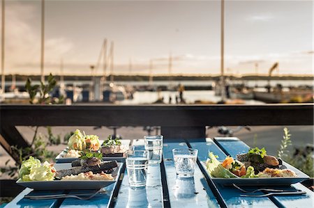 fine dining table setting with glasses - Table set with meals by marina, Reykjavik, Iceland Stock Photo - Premium Royalty-Free, Code: 649-07239788