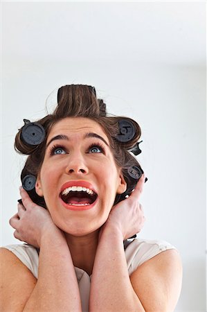 people looking up suprised - Young woman wearing hair rollers looking up Stock Photo - Premium Royalty-Free, Code: 649-07239822