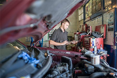 Mechanic holding tool in garage Stock Photo - Premium Royalty-Free, Code: 649-07239906