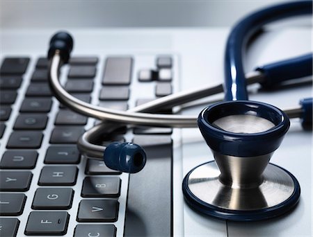Stethoscope sitting on laptop illustrating online healthcare and doctor's desk Stock Photo - Premium Royalty-Free, Code: 649-07279536