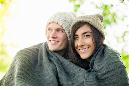 Young couple wearing knit hats wrapped in blanket Stock Photo - Premium Royalty-Free, Code: 649-07279649