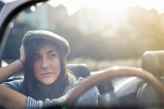 Young woman wearing flat cap in convertible Stock Photo - Premium Royalty-Free, Image code: 649-07279670