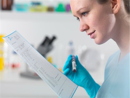 Technician holding blood sample in clinical laboratory with test results Stock Photo - Premium Royalty-Free, Code: 649-07279773