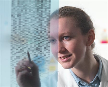 Female researcher examining DNA autoradiogram gel in laboratory Stock Photo - Premium Royalty-Free, Code: 649-07279835