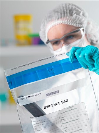 simsearch:649-08714880,k - Forensic scientist holding evidence bag from crime scene in laboratory Foto de stock - Sin royalties Premium, Código: 649-07279845