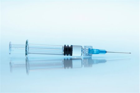 Disposable plastic medical syringe with attached hypodermic needle Stock Photo - Premium Royalty-Free, Code: 649-07279868