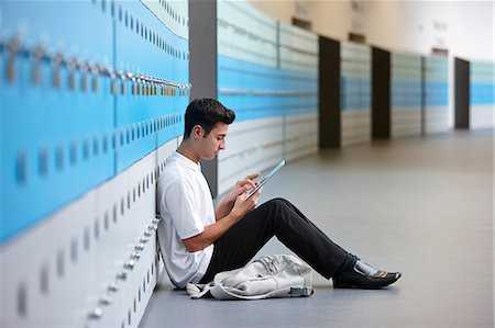 Portrait of teenage schoolboy sitting on floor next to lockers Stock Photo - Premium Royalty-Free, Code: 649-07280065