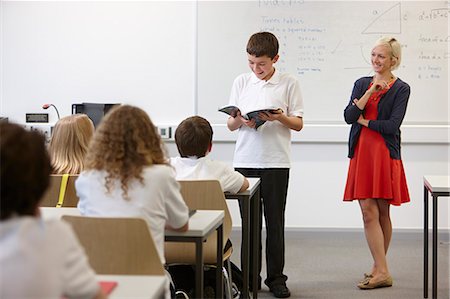 success and teamwork - Schoolboy reading from textbook in front of class Stock Photo - Premium Royalty-Free, Code: 649-07280096