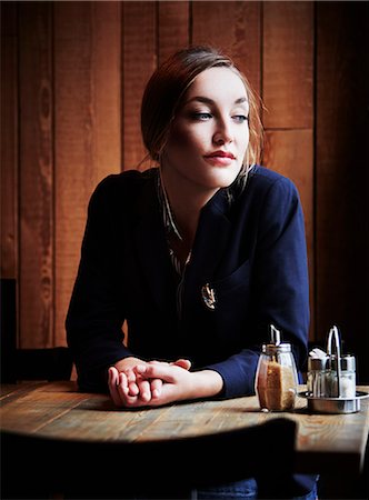 shopping jacket - Young woman sitting in cafe with hands clasped Stock Photo - Premium Royalty-Free, Code: 649-07280183