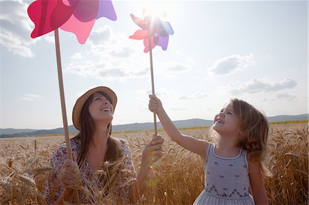 Mother and daughter in wheat field holding windmill Stock Photo - Premium Royalty-Free, Code: 649-07280281