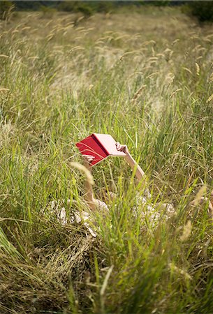 Woman lying in long grass reading book Stockbilder - Premium RF Lizenzfrei, Bildnummer: 649-07280294