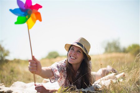 simsearch:649-07280307,k - Woman lying in on front holding windmill Stock Photo - Premium Royalty-Free, Code: 649-07280298