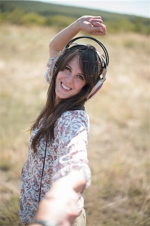 simsearch:649-07280307,k - Portrait of mid adult woman dancing in field with arms raised, wearing headphones Stock Photo - Premium Royalty-Free, Code: 649-07280305