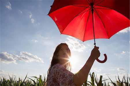 simsearch:649-07280307,k - Woman standing holding red umbrella Stock Photo - Premium Royalty-Free, Code: 649-07280318