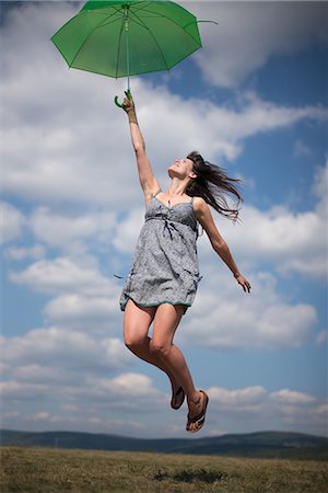 simsearch:649-07280307,k - Mid adult woman holding green umbrella, jumping Stock Photo - Premium Royalty-Free, Code: 649-07280313