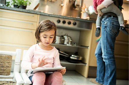 Girl using digital tablet in kitchen Photographie de stock - Premium Libres de Droits, Code: 649-07280356