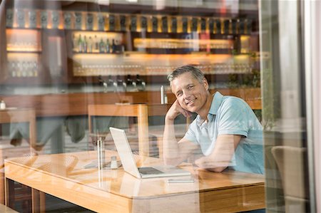 simsearch:649-07280451,k - Businessman using laptop, view through window Photographie de stock - Premium Libres de Droits, Code: 649-07280478