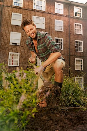 private garden - Mid adult man digging on council estate allotment Stock Photo - Premium Royalty-Free, Code: 649-07280491