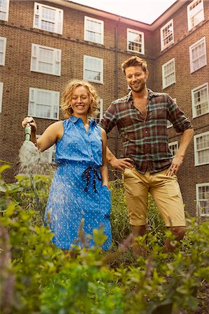 smiling working men building outdoor - Couple watering vegetables on council estate allotment Stock Photo - Premium Royalty-Free, Code: 649-07280493