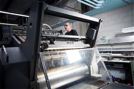 Worker operating printing machine in print workshop Foto de stock - Sin royalties Premium, Código: 649-07280527